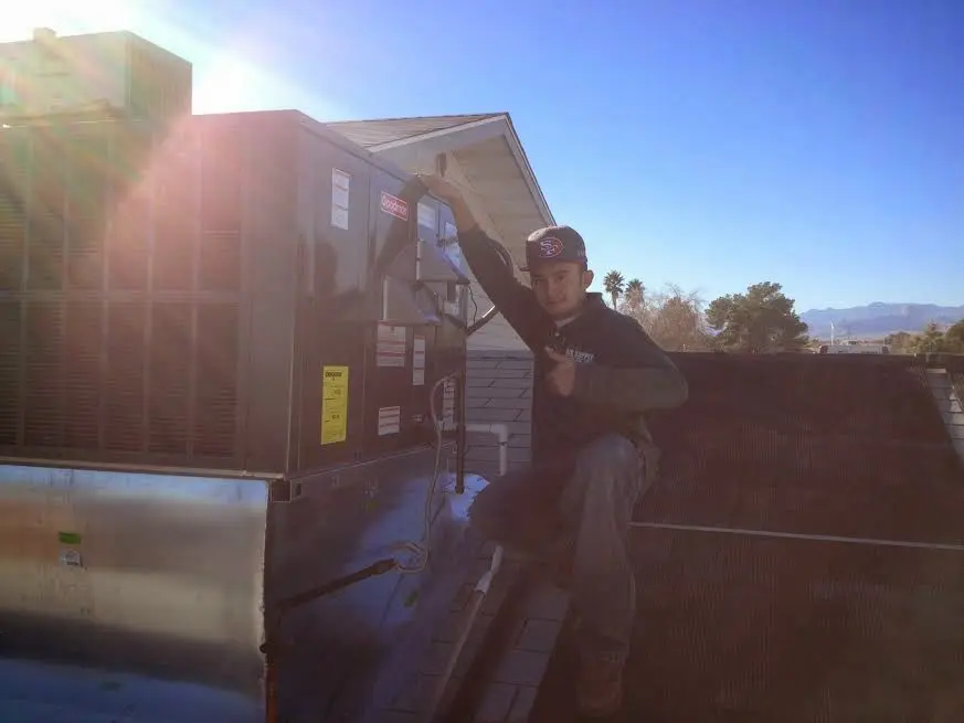 HVAC technician performing AC Tune-Up on a rooftop unit in Denair